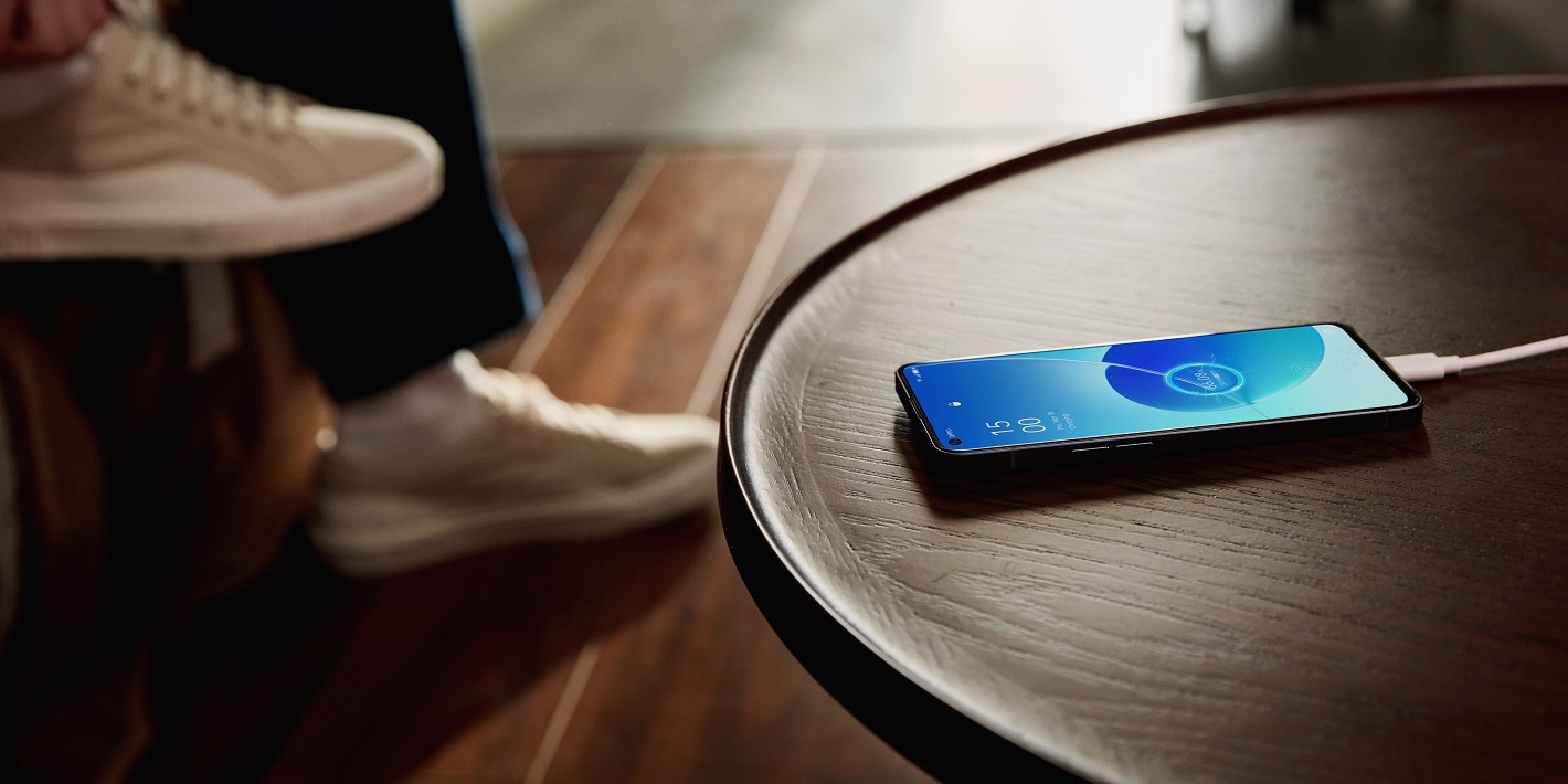 Na zdjęciu leżący na stoliku smartfon Oppo Reno 6