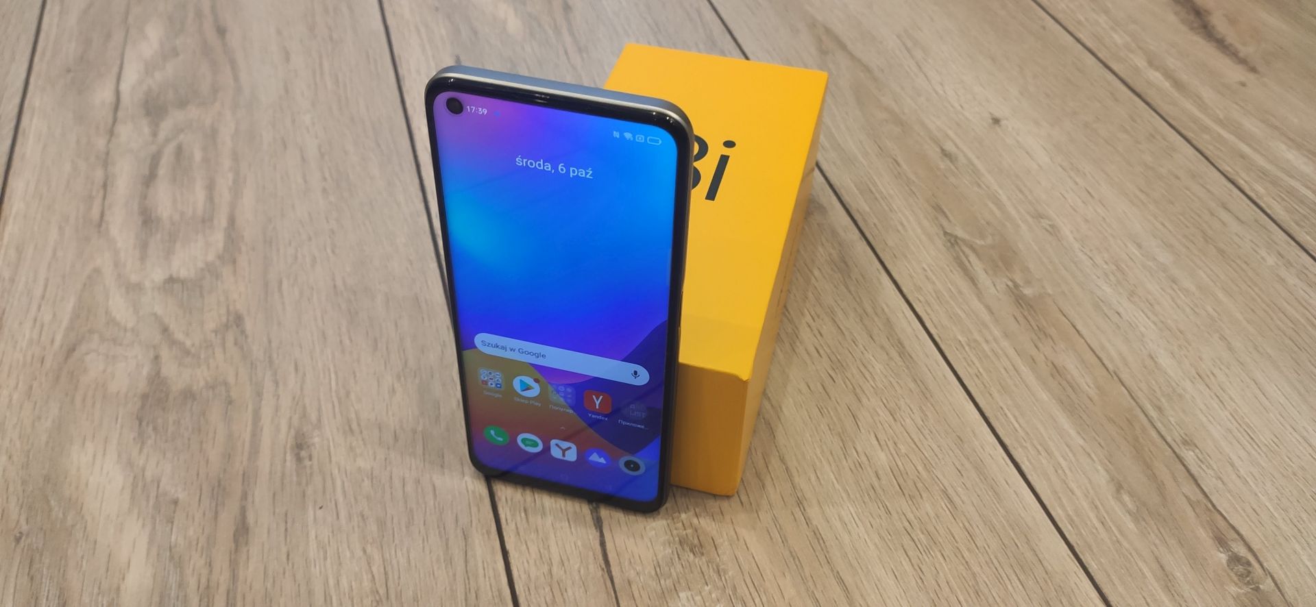 Na zdjęciu smartfon realme 8i wraz z pudełkiem