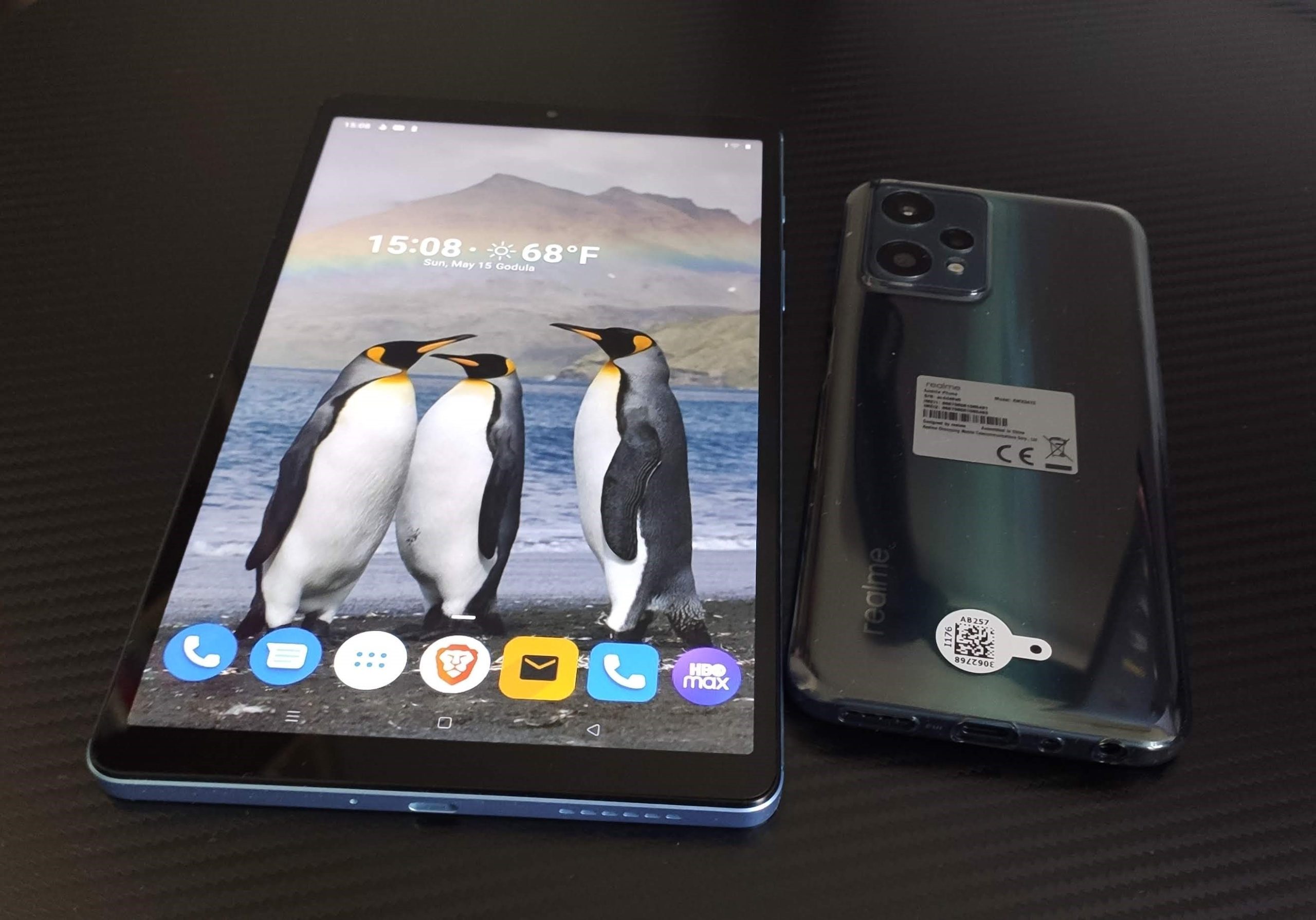 Na zdjęciu realme pad mini w porównaniu rozmiarów z telefonem realme 9 pro